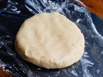 step3: 然後推成麵糰，如麵團太乾，再加點水，太濕潤就加點麵粉。 堆成麵糰便可（不用搓的），搓圓，然後按壓一下，用保鮮紙包好，放入雪櫃一個小時 （不要一次過落所有水，逐少下)