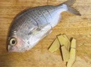 step2: 在鮮魚兩面各割三刀，並在魚身上用鹽抹勻；薑切片。