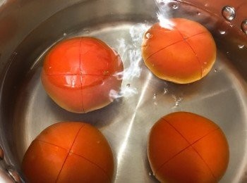 step3: 蕃茄在底部𠝹十字，放入滾水煮約1分鐘，取出去皮及籽，將茄肉切碎。備用。