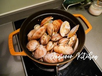 step5: 當大蜆半開口時，把醬油水和米酒倒入。