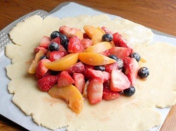 step5: 在枱上灑少許麵粉，放上麵糰，用擀麵棒擀成圓形，在批皮中間放上水果，然後將周邊的批皮向內摺好