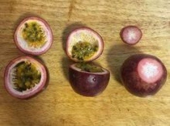 step2: 百香果從尾端切一小片下來，讓百香果能穩穩的站好；接這從另一頭約1/4處切開，以便取出百香果粒和汁；