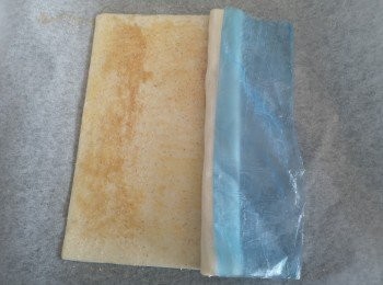 step2: 現成酥皮冰箱取出後，略為回溫，酥皮稍為軟化後，酥皮掃上牛油液，再撒上肉桂糖，酥皮分中後，左右平均各摺兩次或三次，這條是三次效果。