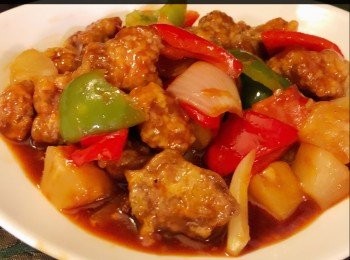 step7: 將肉排返炸，皮便會更加脆。收小火加入青、紅椒，洋蔥及菠蘿粒撈勻，再倒入<span class="group_2">酸甜汁</span>，迅速翻炒均勻。