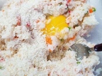 step4: 加入雞蛋和約100g麵包糠(可分次加入，視乎可否搓成球形而又不散開的)拌勻，混合所有材料後，如發現太濕，可再逐少加入麵包糠(額外份量)/1-2湯匙麵粉。