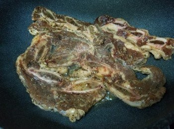 step2: 鑊燒熱，加入適量油，倒入醃好的牛仔骨，大中火煎1分鐘