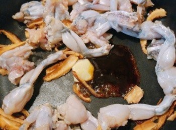 step3: 在鑊中下油爆香薑片，加入田雞、冬菇絲、蠔油和糖大火炒勻。