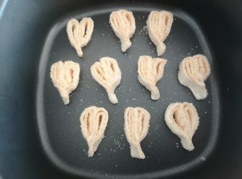 step4: 平均1cm切一切，尖尖按壓一下，型成心形效果，將切好的蝴蝶酥底面印上肉桂糖，放入烤焗盤，請每隻蝴蝶酥需預留空間焗製，氣炸鍋用185度預熱3分鐘。