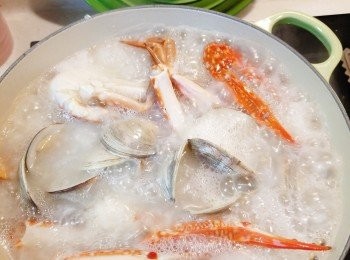 step5: 飯煲煮好粥，將粥轉至LC鍋/其他鍋，放入蟹和蜆，以中火煮約10分鐘，小火再煮5分鐘，放入鹽和胡椒粉調味，熬粥的過程中要間中輕輕攪動粥（鍋底也要攪到，防鍋底沾黏）， 直到粥的濃稠度合意，最後灑上薑絲並關火，出鍋前灑入蔥粒。
