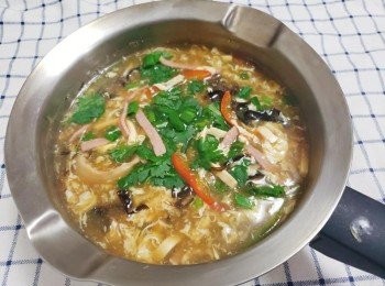 step8: 這時邊用湯勺攪動邊倒入蛋液，熄火。然後加入陳醋胡椒粉水和芝麻油攪勻後試味。最後加入一些香菜蔥花點綴即可。