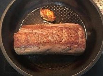 step6: 整條的菲利牛排先用鹽和胡椒粉調味；鍋燒熱放入橄欖油和切半的蒜頭，牛排入鍋將四面和兩邊都要煎上色，以鎖住肉汁。