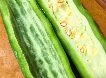 step1: 涼爪沖洗後，把苦瓜對半剖開，用匙把瓜瓤部分刮除，盡量把裡面白色部分刮乾淨。