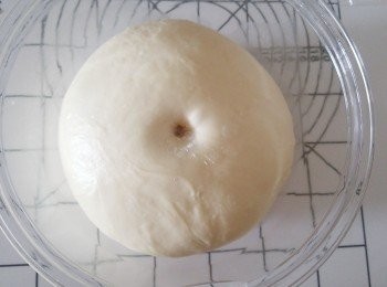 step6: 取出基本發酵好的麵糰。（將食指沾滿高筋麵粉，從中間刺到底再抽出來，如果指孔不回縮，就表示基本發酵完成。）取出麵糰，排氣及翻麵，將麵糰分割成9份麵糰，每份約60g，然後滾圓。