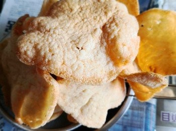 step1: 先找一個小號煎 pan放2湯匙油以小火將油微熱了便放入乾蝦片泡到邊沿開始發泡便要離火先將蝦片用筷子撐開至平整（不要被油泡到卷起）