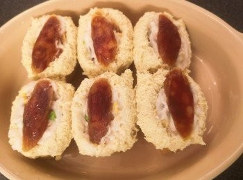 step4: 將臘腸墨魚滑釀入油揚，袋口反摺一下，再放上一片臘腸，蒸12分鐘。