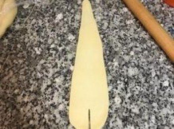 step15: 取第一顆水滴<span class="group_2">麵糰</span>, 桿麵棍從<span class="group_2">麵糰</span>最厚的地方壓下,一手抓著水滴<span class="group_2">麵糰</span>的細端,一手向前移動桿麵棍,然後再往回桿,讓<span class="group_2">麵糰</span>的厚度一致.接著在麵皮最寬的地方劃開一刀；