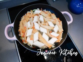 step6: 當鍋裡的材料都炒香後，加水簡單煮3-5分鐘成湯。加入年糕吸收高湯和煮軟，大約煮3分鐘。