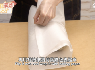 step6: 再用烤焙紙將荷葉雞包裹起來。Wrap the chicken with baking paper on top of the lotus leaf. Make sure the sides are well covered.