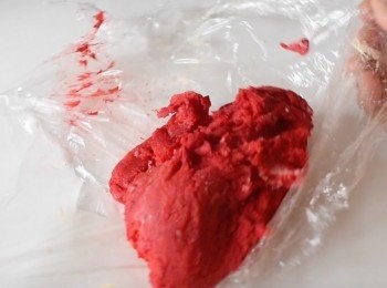 step4: 將麵糰分成小份(約10克)，搓成4 至5吋長的長條。將一條普通麵糰及一條紅色麵糰疊在一起，然後輕力扭數下，再做成柺杖狀，放在烘焙紙上