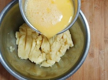 step7: 面團取出放入一個大容器內，放至微溫。蛋液分三次加入面團內，