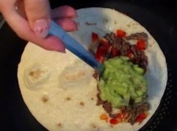 step5: 炒熟免治牛肉及紅椒，白鑊烘墨西哥烤餅皮, 同時將1湯匙芝士碎放在半塊烤塊上, 加入紅椒, 免治牛肉及牛油果醬(份量隨個人口味), 然後對摺, 反轉再烘十零秒