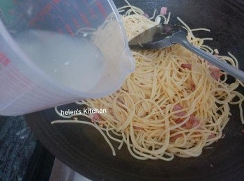 step6: 加入意粉和意粉水，加適量鹽和胡椒粉，轉回中火炒一分鐘，