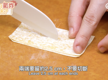 step1: 把每塊雲吞皮對褶，用鋒利的小刀在中央割一條縫，兩端要留約2½ cm，不要切斷。Fold the Wonton Skin into half, cut a hole in the middle with knife, leave 2½ cm at each ends