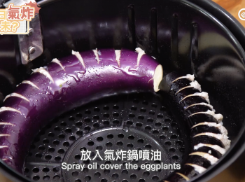 step4: 放入氣炸鍋噴油。
Spray oil over the eggplants.