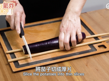 step1: 用筷子輔佐切茄子，避免切斷。
Place the eggplant between the handles of 2 chopsticks.