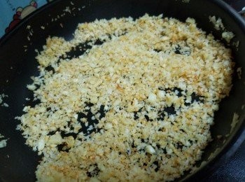 step6: 不粘鍋洗淨燒熱，倒入少許油，再倒入蒜蓉碎、下幼鹽、炒至蒜頭變色，最後倒入麵包糠,炒到麵包糠金黃色即可