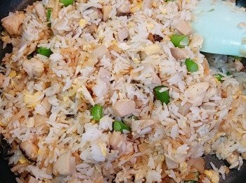 step8: 加入飯（轉細火)，撥散並慢慢炒勻，用鏟背一邊按壓一邊炒飯粒。再一邊炒一邊灑下適量的鹽、糖作調味，要試味。