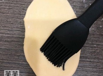 step3: 用麵粉桿將麵團碌至橢圓形，再把油掃上表面，然後對摺放於牛油紙上。