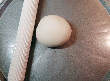 step5: 隨即取出麵糰滾圓後(不用等發酵)放上pizza焗盤(先塗上少許油)上，擀成薄圓形(擀得越薄越脆，所以大家要努力擀呀💪haha~)。