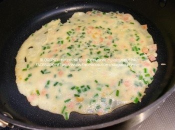 step5: 燒熱油鍋，倒入適量的粉漿，搖勻鋪平成圓形；灑上少許葱粒。