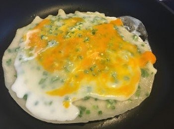 step5: 蛋液開始熟(如圖), 就可以舖火腿碎入去