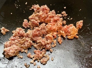 step3: 於鑊中燒熱油，中火炒豬絞肉至半熟，倒入蒜蓉同炒。