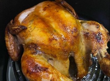 step2: 用微波爐把20克牛油叮成溶液，混合2茶匙蜜糖，加半個檸檬汁拌勻，把1/2汁料掃上春雞，200度氣炸5分鐘，翻轉雞身，再把餘下汁料掃上，氣炸5分鐘，用竹籤或筷子插入最厚肉位置，如容易插入，沒有血水流出代表已熟透（如未熟透，可再氣炸幾分鐘至熟透）。