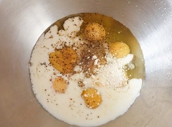 step2: 在大碗內打發雞蛋、牛奶，下鹽和黑胡椒粉調味. 再加入芝士和所有煮熟的餡料，拌勻