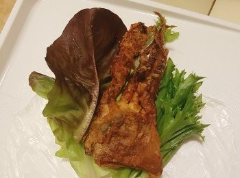 step5: 準備一碟温水，將一張米紙放入稍微沾濕一下，不要浸泡，避免太過濕而不易捲起且容易破爛，取出放在一塊布巾上吸一吸水，再鋪在台上，在米紙中央放上沙律菜、已炸好的軟殼蟹和牛油果， 並緊緊地包好捲成卷狀即成。