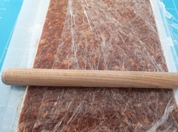 step3: 底鋪烘焙紙，免治豬肉放面，再鋪上保鮮紙，用木棒碌成薄片，肉乾約4-5cm厚，金錢肉乾可厚少少。