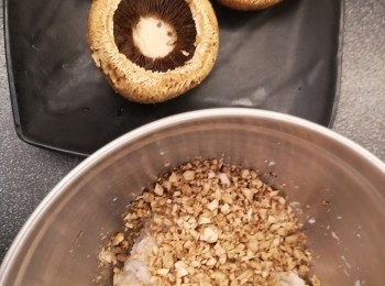 step1: 芝士蝦釀大啡菇做法：
蒜頭剁蓉，用牛油爆香，盛起備用，大啡菇去菇蒂，用濕布抹乾淨，菇蒂剁碎。蝦膠加入醃料攪勻。菇蒂碎、蝦膠和35克碎芝士混合攪勻成大啡菇蝦滑餡料，一半材料釀大啡菇，一半材料做椰菜卷