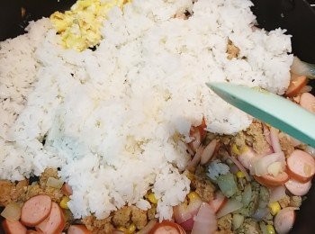 step7: 待蛋炒散至較乾身才加入飯（依舊細火)，撥散並慢慢炒勻，用鏟背一邊按壓一邊炒飯粒，如是者炒至粒粒分明。　
