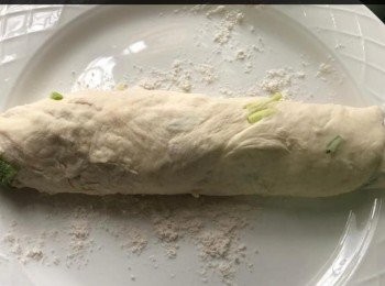 step2: 準備麵糰放在板上，撒在麵粉上，並在手上輕輕的楺成圓形。 以麵棍將麵糰摲成一塊長的麵皮。