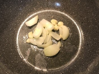 step3: 鍋燒熱放入油，炒香蒜頭與半顆洋蔥；