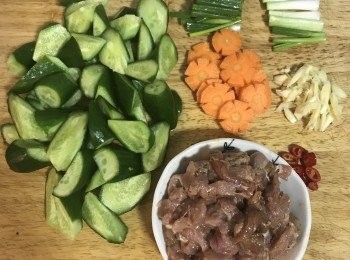 step3: 小里肌肉絲用醃料抓勻；蒜拍扁去皮切片；辣椒去籽切圈狀；蔥切段並將蔥白和蔥綠分開放，紅蘿蔔切片；小黃瓜滾刀切；