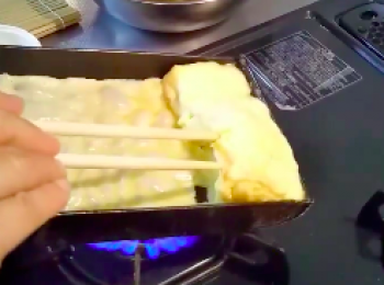 step8: 同時擡起一點剛才卷好的蛋卷，讓蛋液流到蛋卷底下。 再 一層一層地卷起来。