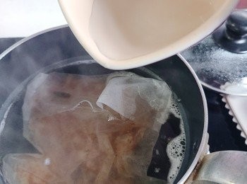 step3: 取出昆布後再開火煮至大滾 ，加入柴魚片（ 我先用大號泡茶袋裝入， 方便之後不用過濾），隨即注入少量凍熟水（此舉乃降温有助抑壓鰹魚腥味)，最小火煮3分鐘。