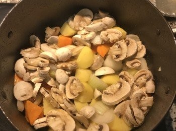 step5: 取出雞腿肉，放入蒜皮與洋蔥塊炒香後，再放入蘑菇片拌炒；
