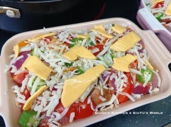 step6: 焗盤內依序放入螺絲粉、汁料、秋葵粒，灑上三種芝士；放進已預熱的焗爐，以220c焗約5-8分鐘焗至芝士溶化，即成。