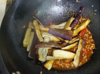 step2: 茄子切斷浸水加醋10分鐘防止變黑,茄子放入鍋中半煎炸至金黃撈起備用，乾蔥，蒜蓉放入鑊中炒香加入豆瓣醬二湯匙，沙嗲醬半湯匙，加入肉鬆炒香加入水份，加入雞粉，糖，加入茄子一同炒半乾身加入適量美極兜起加入蔥粒，加入辣椒粒，肉鬆茄子完成